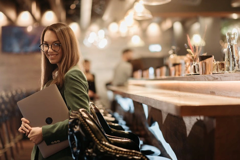Uśmiechnięty analityk biznesowy przeglądający dane na laptopie.